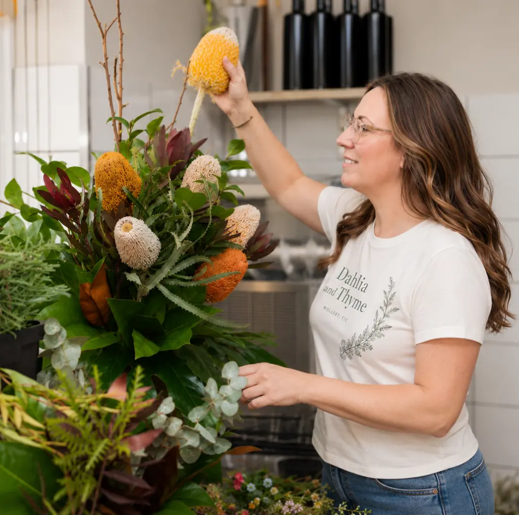 Florist creating a native floral arrangement in the Dahlia and Thyme studio using seasonal flowers and foliage.