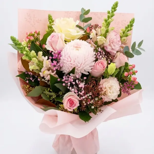 Pretty pink seasonal flowers featuring roses, chrysanthemums, snapdragons and fresh foliage wrapped in soft pink paper.