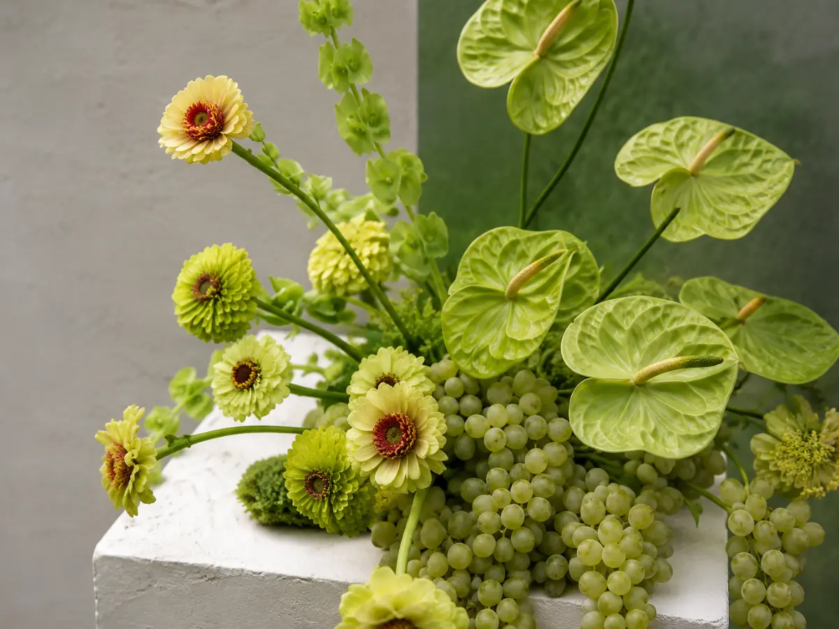 Organic wedding flower arrangement featuring green grapes, anthuriums and seasonal blooms, showcasing the 2026 wedding flower trend of incorporating fruit into wedding flowers.